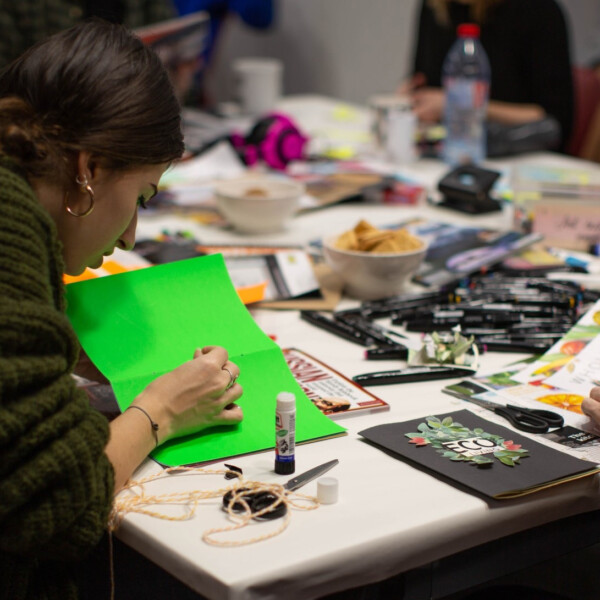 A group of people are sat in the Brockway Room at Conway Hall. they are working on creating zines.